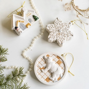 Set of white Christmas ornaments including house, snowflake and polar bear shapes with gold strings