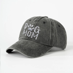 Detailed close-up of DOG MOM embroidery and washed denim texture on a dark grey baseball cap