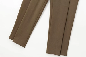 Dettaglio della trama del tessuto verde oliva scuro e cuciture di precisione dei pantaloni