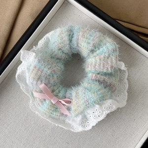 Detail of plush blue and pink scrunchie with delicate lace edges and a sweet pink bow