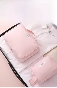 Détail de trousses de maquillage roses imperméables en deux tailles sur des vêtements
