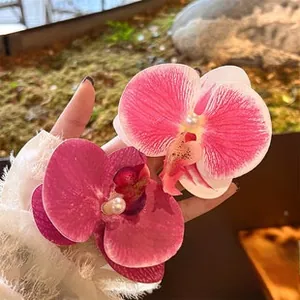 Detail einer Orchideen-Haarklammer mit Perlen vor natürlichem Mooshintergrund