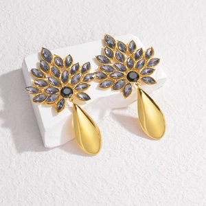 18K gold teardrop earrings with purple marquise gems and black center on stone block