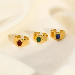 Detailed shot of three bohemian gold open rings with red, green, and blue oval gemstones