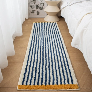 Thick plush bedroom rug with blue and white stripes and yellow trim on wood floor