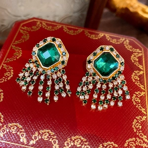 Gros plan de boucles d'oreilles vintage avec glands en cristal émeraude sur boîte