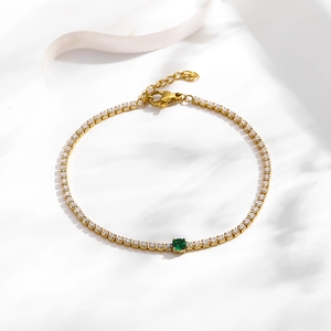Elegant gold tennis bracelet with shimmering white zircons and a central green gemstone