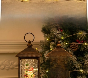 Detail of vintage Christmas lantern with internal snow globe scene and LED light