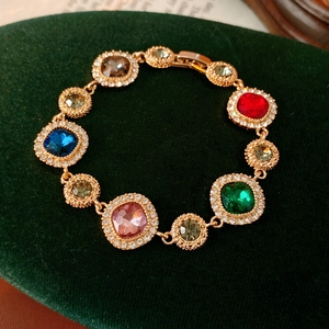 Detailed close-up of colorful vintage crystal bracelet on dark green velvet background