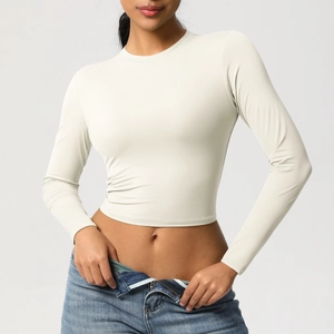 Détail du tissu doux et extensible sur un t-shirt de sport beige à manches longues moulant