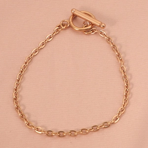 Close-up of rose gold toggle clasp necklace with geometric OT buckle detail
