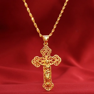 Macro shot of gold cross pendant with intricate cutout detailing and jesus icon