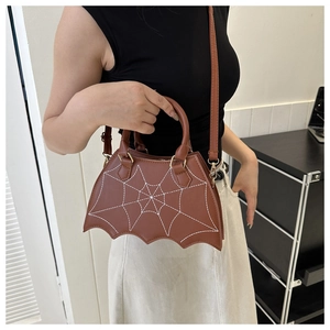 Brown bat-shaped crossbody bag with white spiderweb stitching and adjustable strap