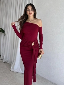 Detail of burgundy one-shoulder dress featuring waist pleats and gold metal buckle accent