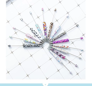 Close-up of telescopic beaded pens with diverse leopard and floral patterns on metal body