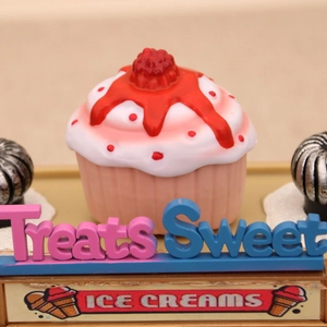 Detailed view of pink Christmas cupcake music box with berry topper and dessert signage