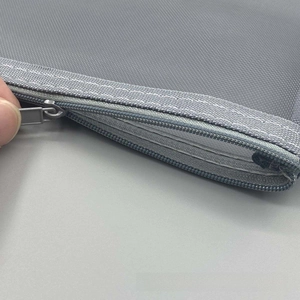 Dettaglio della trama in nylon e cerniera metallica dell'astuccio a rete trasparente