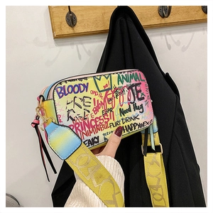 Close-up of colorful graffiti print camera bag with wide woven strap and metal zipper