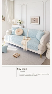 Detail of light blue quilted cotton sofa cover with baroque patterns and matching cushions