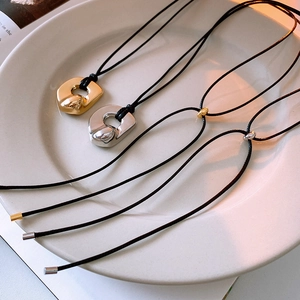 Detailed view of gold and silver irregular lava pendants on black leather cords