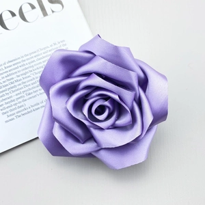 Detailed macro shot of light purple handmade satin rose camellia accessory with silk texture