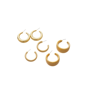 Three pairs of golden round hoop earrings with polished and textured metal finish set