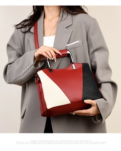 Detail of color-block tote bag with litchi grain texture and metal handle on model