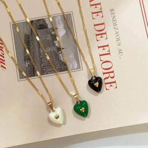 Detailed close-up of heart pendants on gold-plated chain laid on a vintage magazine