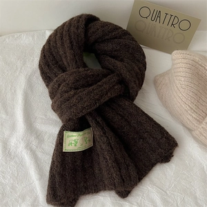 Detailed view of dark brown Shetland Virgin Wool knit scarf with texture and fabric tag