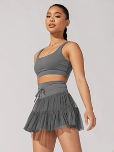 Detail of grey high-waisted pleated sports skirt and matching athletic vest set