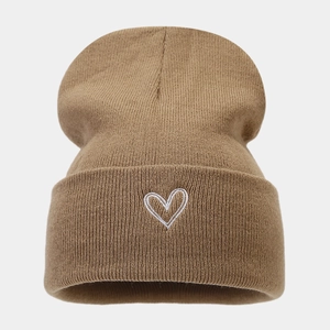 Close-up of heart embroidery detail on thick camel knit beanie for winter styling