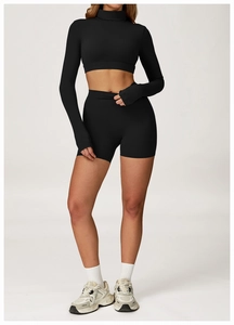 Détail de l'ensemble de yoga noir avec crop top à col montant et poignets passe-pouce