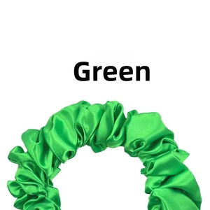 Detailed view of bright green pleated satin fabric texture on an elastic scrunchie
