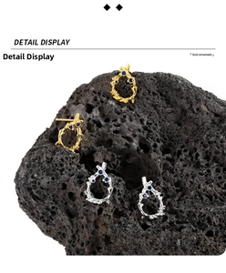 Macro detail of irregular S925 silver lava earrings with blue stones on volcanic rock