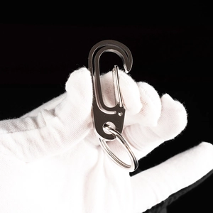 Detail of silver stainless steel carabiner keychain with round ring on black background