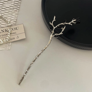 Detail of silver branch hair stick with black flower petals in minimalist retro style