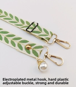Detail of adjustable phone strap with green leaf pattern and golden metal lobster clasp
