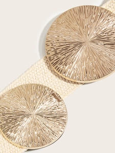 Close-up of woven cream elastic belt with large golden sunburst pattern metal buckles