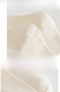 Detail view showing high-elastic ribbed cuff and reinforced heel of cream cotton socks