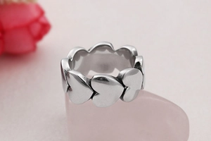 Macro shot of silver overlapping heart ring with polished metallic finish detail