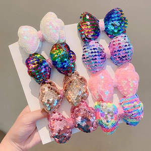 Set of 8 colorful laser sequin bow hair clips for girls displayed on white cardstock