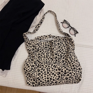 Dettaglio di una borsa tote in tela leggera con stampa leopardata su coperta bianca