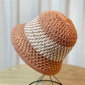 Detail of hand-woven striped bucket hat in brown and white crochet texture for summer