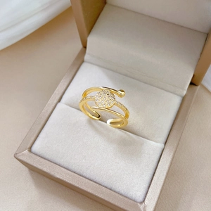 Gouden verstelbare ring met drie lagen en glanzende zirkonia in een fluwelen sieradendoos
