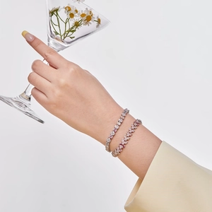 Detail of silver S925 bracelets with pink and white cubic zirconia on a wrist