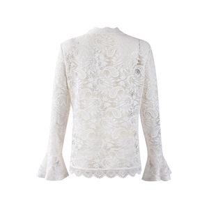 Close-up of white floral lace fabric with elegant bell sleeve details on women's top