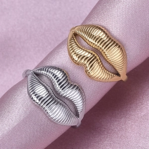 Adjustable lip shaped rings in gold and silver with vertical texture on pink silk fabric