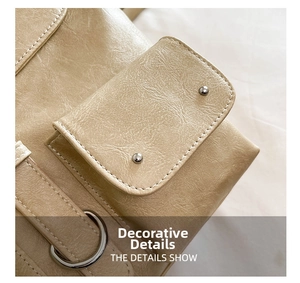 Detail shot of beige leather backpack featuring stitching and silver metal hardware