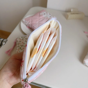Detail showing open pink floral quilted pouch holding personal care items in soft cotton