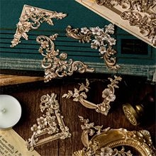Close-up of vintage bronze and gold filigree metal corner protectors for scrapbook